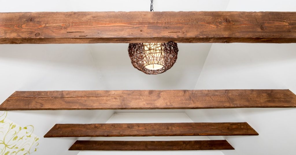 Faux wood beams installed across an a-shaped ceiling, creating the illusion of greater height and airiness.